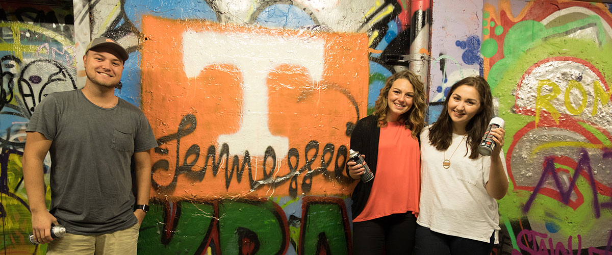 Students Studying abroad with a UT mural